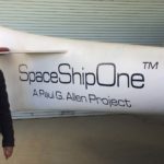 Topher Hopkins with camera in front of spaceship prototype at Virgin Galactic