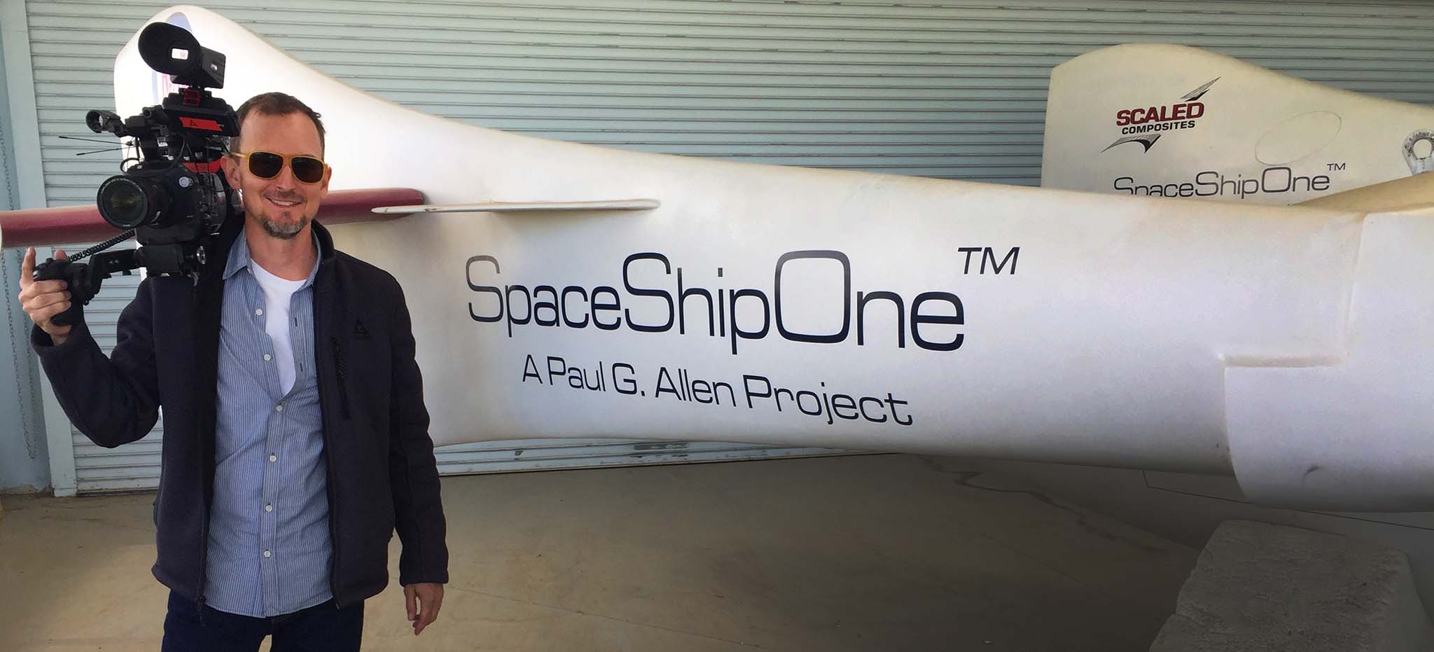 Topher Hopkins with camera in front of spaceship prototype at Virgin Galactic